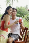 Couple with drinks, looking away - Asia Images Group