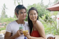 Couple with drinks, looking away, portrait - Asia Images Group