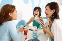 Young women in cafe, talking over drinks - Asia Images Group