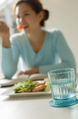Young woman eating salad, focus on the foreground - Asia Images Group