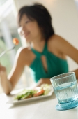 Young woman eating salad, selective focus - Asia Images Group