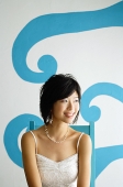 Young woman sitting on chair, looking away - Asia Images Group