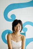 Young woman sitting on chair, looking at camera - Asia Images Group