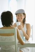 Young women in cafe, sitting face to face - Asia Images Group