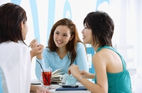 Three young women in cafe, talking - Asia Images Group