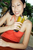 Woman holding drink, smiling - Asia Images Group