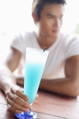 Man with drink, looking away, selective focus - Asia Images Group