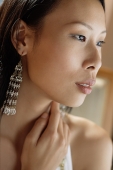 Woman looking away, hand on neck - Asia Images Group