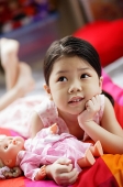 Girl holding a doll, looking up, hand on chin - Asia Images Group