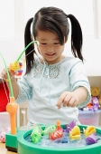 Girl playing with fishing toy - Asia Images Group