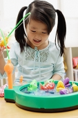 Girl playing with fishing game - Asia Images Group