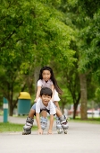 Children rollerblading, boy falling down - Asia Images Group