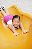 Girl on slide, smiling at camera - Asia Images Group