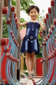 Girl in playground, walking on bridge - Asia Images Group