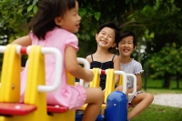 Three girls on a seesaw - Asia Images Group