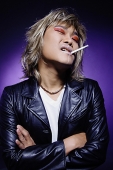 Man in leather jacket, wearing make-up, cigarette in mouth - Asia Images Group