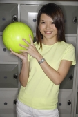 Woman holding bowling ball, smiling - Asia Images Group