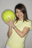 Woman holding bowling ball, smiling at camera - Asia Images Group