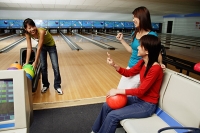 Women in bowling alley, one choosing ball - Asia Images Group