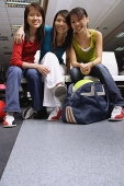 Women sitting side by side in bowling alley, portrait - Asia Images Group