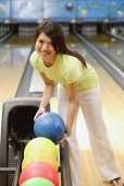 Woman selecting bowling ball - Asia Images Group