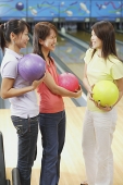 Women at bowling alley, holding bowling balls - Asia Images Group