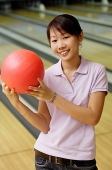Woman at bowling alley with bowling ball - Asia Images Group
