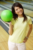 Woman at bowling alley with green bowling ball - Asia Images Group