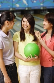 Women at bowling alley, standing side by side - Asia Images Group