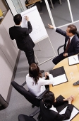 Group having a business meeting, man writing on flipchart - Asia Images Group
