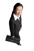 Businesswoman holding briefcase, smiling at camera - Asia Images Group