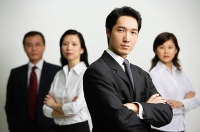 Four business people looking at camera - Asia Images Group