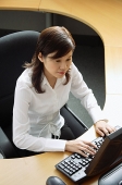 Businesswoman sitting in office cubicle, using computer - Asia Images Group