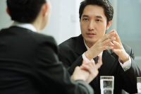 Businessman talking to businesswoman - Asia Images Group