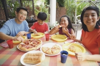 Family of four having pizza at home - Asia Images Group