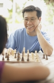 Father playing a game of chess with daughter - Asia Images Group