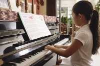 Girl playing piano at home - Asia Images Group