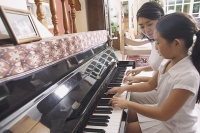 Mother and daughter playing the piano - Asia Images Group