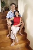Couple sitting on stairs, smiling at camera - Asia Images Group
