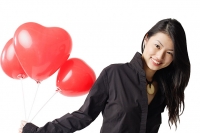 Woman holding three red balloons, portrait - Asia Images Group