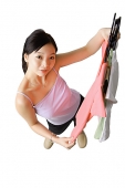Woman holding up clothes on hangers - Asia Images Group