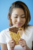 Woman with a bar of chocolate - Asia Images Group