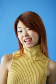 Woman wearing turtleneck, winking and sticking out tongue - Asia Images Group