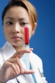 Female doctor looking at syringe - Asia Images Group