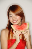 Woman holding a slice of watermelon, smiling - Asia Images Group