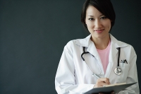 Female doctor, holding clipboard, looking at camera - Asia Images Group