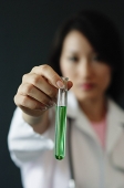 Doctor holding test tube filled with green liquid, selective focus - Asia Images Group
