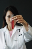 Doctor holding test tube filled with red liquid, selective focus - Asia Images Group