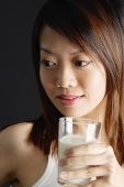 Young woman holding glass of milk - Asia Images Group