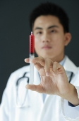 Doctor holding syringe - Asia Images Group